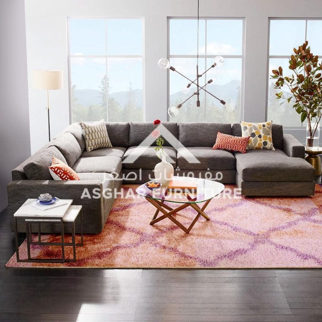 A cozy living room featuring a sectional couch and a stylish rug, creating a welcoming atmosphere for relaxation.