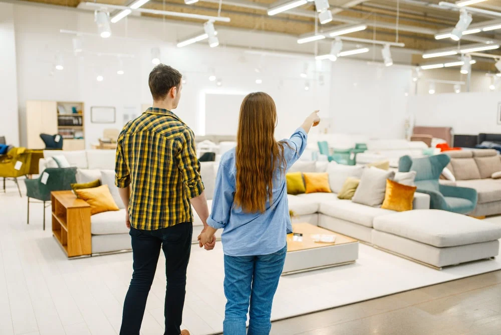 A couple looks at furniture in a store and talks about what they like and what their options are.
