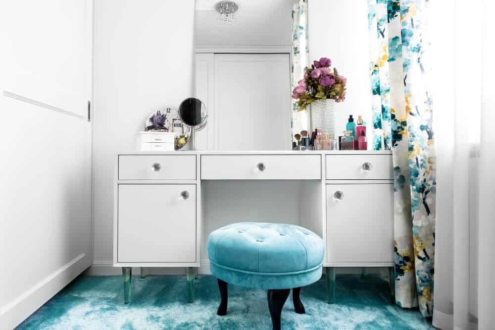 A white vanity adorned with blue and white flowers, creating a fresh and elegant atmosphere