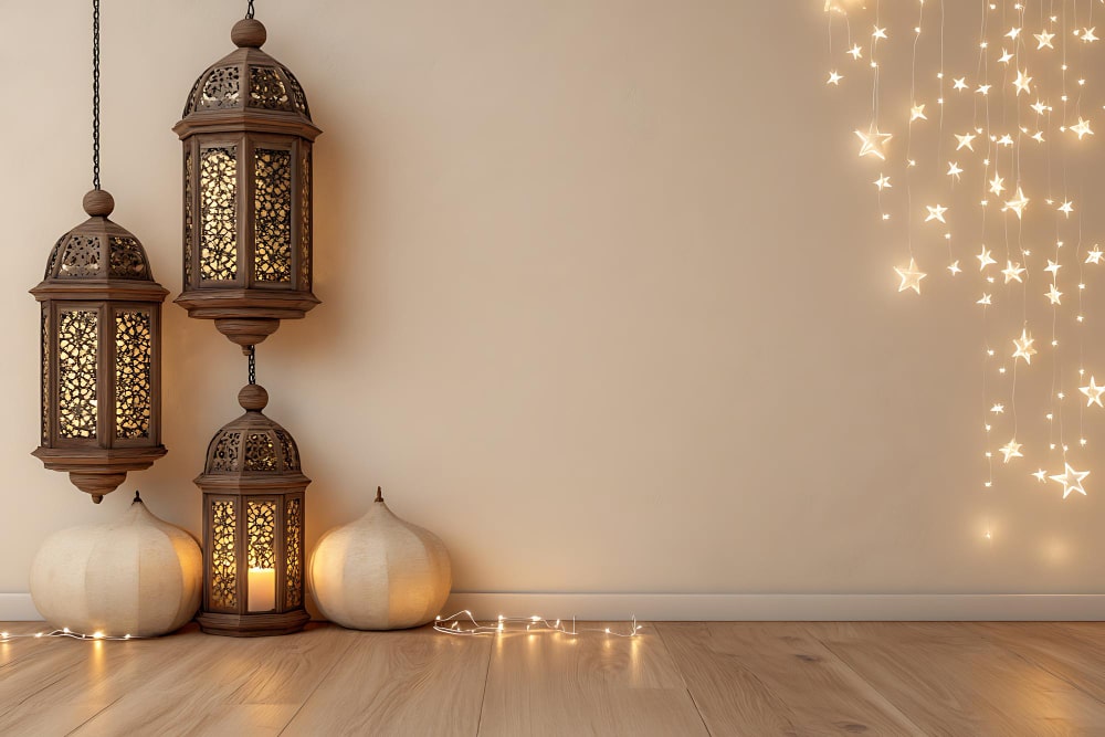 Three decorative lanterns and a lit candle arranged on a rustic wooden floor, creating a warm and inviting atmosphere.